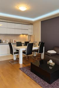 a living room with a white table and chairs at Sajam Nest Apartment in Novi Sad
