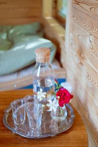 a glass bottle on a tray with glasses and a flower at Tyrolens vagnshotell in Alvesta +28 photos