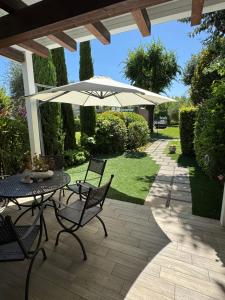 a patio with a table and chairs and an umbrella at Eden Patio 26 Sassabanek in Iseo