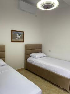 a bedroom with two beds and a ceiling fan at Guest house Irvin in Berat