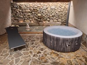 a hot tub in a room with a stone wall at Vila Anton in Dobrna +23 photos