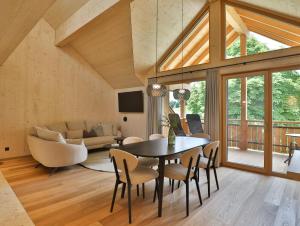 a dining room and living room with a table and chairs at Mair am Graben Farm Chalets in Terento