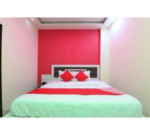 a bedroom with a large bed with a red wall at Hotel Lakhdatar Palace in Jaipur