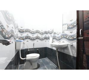 a bathroom with a toilet and a sink at Hotel Lakhdatar Palace in Jaipur