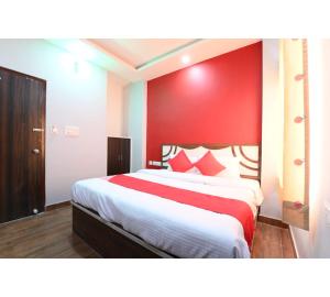 a bedroom with a large bed with a red wall at Hotel Lakhdatar Palace in Jaipur