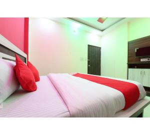 a bedroom with a large bed with red pillows at Hotel Lakhdatar Palace in Jaipur