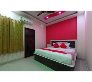 a bedroom with a bed and a red wall at Hotel Lakhdatar Palace in Jaipur
