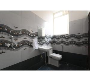 a bathroom with a sink and a toilet at Hotel Lakhdatar Palace in Jaipur