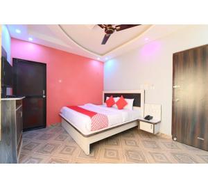 a bedroom with a bed and a red wall at Hotel Lakhdatar Palace in Jaipur