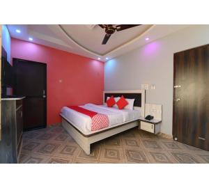 a bedroom with a bed with a red wall at Hotel Lakhdatar Palace in Jaipur