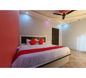 a bedroom with a large bed with red pillows at Hotel Lakhdatar Palace in Jaipur
