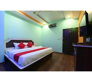 a bedroom with a large bed with red pillows at Hotel Lakhdatar Palace in Jaipur