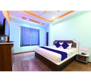 a bedroom with a bed with blue walls and a television at Hotel Lakhdatar Palace in Jaipur
