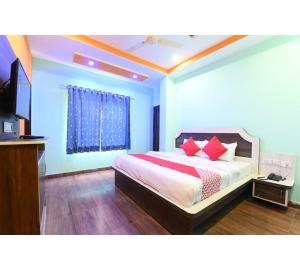 a bedroom with a bed with red pillows at Hotel Lakhdatar Palace in Jaipur