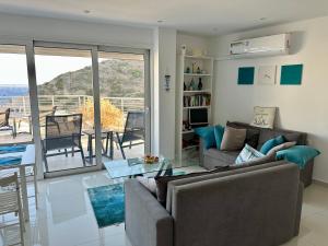 a living room with a couch and a table at Kim Penthouse Apartment in Agia Galini