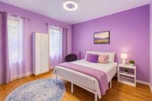 a purple bedroom with a bed and a purple wall at Lavender style Room in New York
