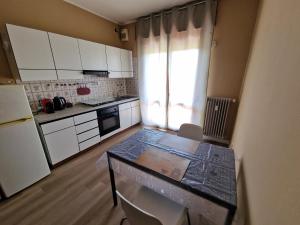 a kitchen with white cabinets and a table with chairs at Casa Gemma in Padova