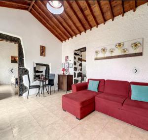 ein Wohnzimmer mit einem roten Sofa und einem Tisch in der Unterkunft Northeast Azores, Rocha Mar House in Nordestinho