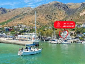 戈登湾'24 Gordonia', Spacious Condo - Sleeps 7, Sea Front, Easy Beach access的一艘在水体中带有标志的船