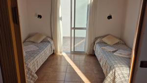 two beds in a room with a view of the ocean at Excelente Bungalow en San José, Entre Ríos in San José