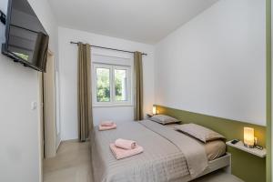 a bedroom with a bed with pink towels on it at Villa FUSKA with private pool in Pinezici +33 photos