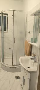 Un baño blanco con ducha y lavabo. en Villa ANA, en Crikvenica