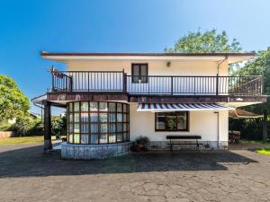 a house with a balcony on top of it at Preciosa y amplia casa con piscina in Liendo