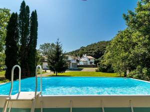 a large swimming pool with a chair in a yard at Preciosa y amplia casa con piscina in Liendo