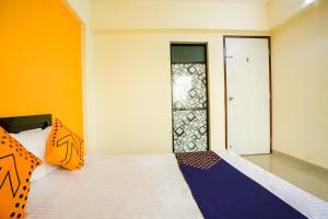 a bed with orange and blue pillows in a room at SPOT ON Pawan Villa in Gorhe
