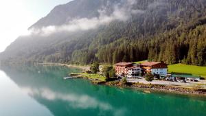 un villaggio sulla riva di un fiume con una montagna di Seehotel St Hubertus a Pertisau