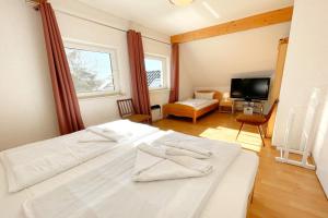 a bedroom with two white beds and a television at Am Waldwinkel Ferienhaus Sonne in Koserow