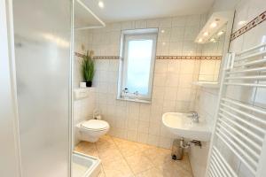 a bathroom with a toilet and a sink at Am Waldwinkel Ferienhaus Sonne in Koserow +12 photos