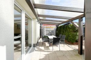 a patio with a table and chairs on it at Am Waldwinkel Ferienhaus Sonne in Koserow