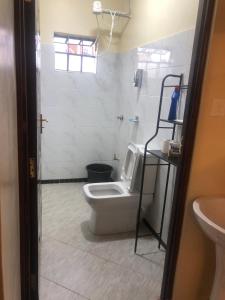 a bathroom with a toilet and a shower and a sink at Snowy stays in Eldoret