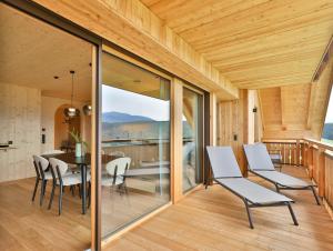a dining room with glass doors and a table and chairs at Mair am Graben Farm Chalets in Terento