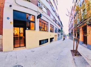 an empty street in a city with buildings at Capsule Inn Madrid in Madrid