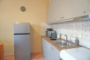 a kitchen with a white refrigerator and a sink at Papadakis Family Home - 1 BR apartment in Asopós +2 photos