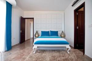 a bedroom with a large bed with blue pillows at Exquisite Protaras Villa Villa Bulat 4 Bedrooms Beachfront Amazing Sea Views Private Outdoor Pool Furished Sun Terrace Ellinon in Protaras +29 photos