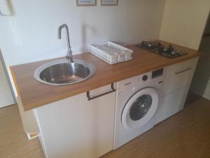 una cocina con fregadero y lavadora en MOBIL HOME le WELCOM, en Valras-Plage