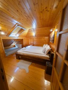 a room with a bed in a wooden cabin at Casa Valea Râului Vârciorog in Vîrciorog