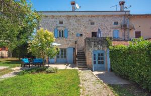 a stone house with blue doors and a yard at Villa Sherpa by Villas Guide in Stranići kod Lovreča