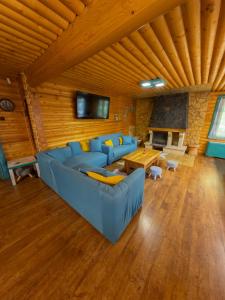 a living room with a blue couch and a table at Casa Valea Râului Vârciorog in Vîrciorog