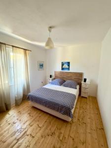 a bedroom with a bed and a wooden floor at Villa Sunny Side in Ždrelac