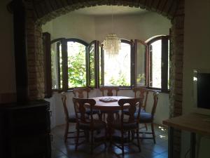 a dining room with a table and chairs and windows at Villa Sunny Side in Ždrelac