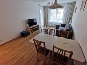 Una sala de estar con una mesa y sillas y un sofá. en Apartamenty Adler - Classic, en Szczecin 4 fotos más