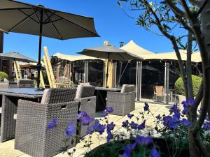a table and chairs with umbrellas and purple flowers at Pontlands Park Hotel in Chelmsford