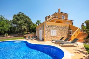 a villa with a swimming pool in front of a house at Vivenda Vale Verde in Carvoeiro