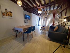a living room with a table and a couch at La Trame Bourguignonne - Centre ville in Auxerre