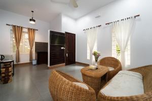a living room with wicker chairs and a television at SANNA VILLA Residence in Siem Reap