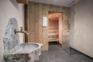 un bagno con vasca in pietra e cabina armadio di Seehotel St Hubertus a Pertisau Altre 37 foto